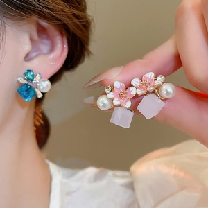 Detail of floral pearl stud earrings with pink cherry blossom and crystal pendants