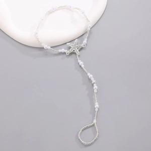 Macro detail of starfish pearl foot chain with shell charms for beach summer jewelry style