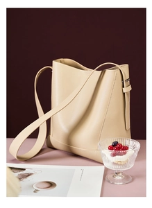 Detail der beigen Leder-Beuteltasche mit Metallschnalle auf elegantem Lifestyle-Hintergrund