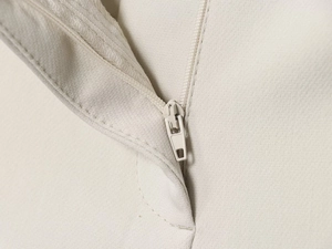 Détail macro de la texture du tissu tissé et fermeture éclair invisible sur pantalon beige