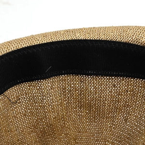 Macro detail of summer straw hat featuring gold sequins and black elastic sweatband