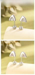 Detail view of cat ear cartilage studs with pink and white zircon in titanium steel