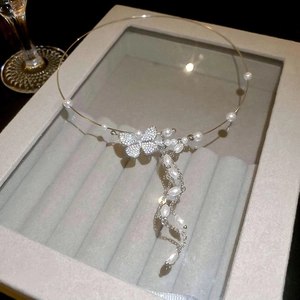 Detailed close-up of a luxury butterfly choker with irregular pearls and tassels