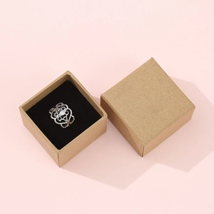 Top view of a vintage silver ring with a white teardrop stone in a kraft paper box