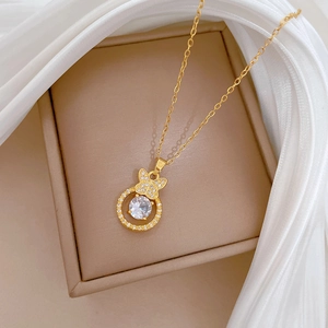 Luxurious gold butterfly circle necklace with sparkling zircons on white fabric