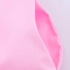 Detail of pink poplin fabric texture showing fine weave and durable double-stitched seams