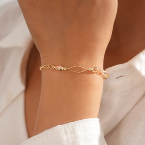 Détail de bracelets bohèmes dorés ornés de gemmes en cristal sur un poignet féminin