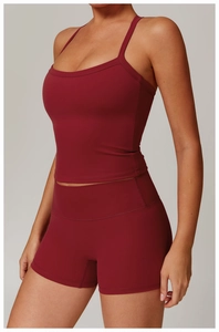 Detail of dark red yoga set featuring thin straps top and high waist compression shorts
