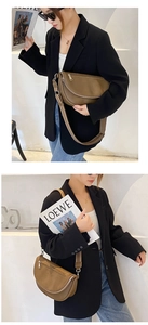 Adjustable brown leather crossbody bag with wide strap shown on a model in a black blazer