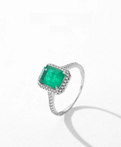 Detail of s925 silver ring featuring emerald-cut green stone and pavé-set diamonds