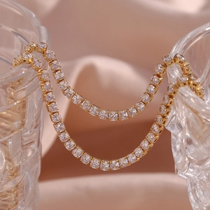 14K gold plated tennis chain necklace with sparkling zircon crystals on a pink background