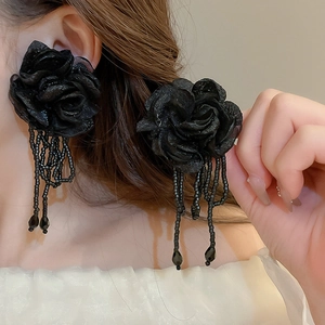 Detail shot of black mesh rose flower earrings with beaded tassels for a dramatic look