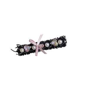 Lace bow hair clip with pink ribbon, faux pearls, and heart crystals on white background