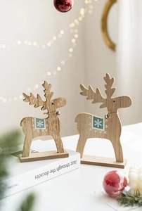 Close-up of wooden Christmas reindeer figurines with snowflake patterns on a festive table