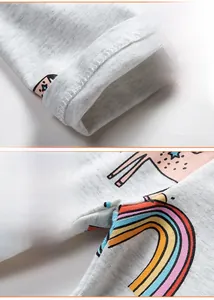 Detail of girls' light gray knit leggings showing rainbow print and fine stitching at cuffs