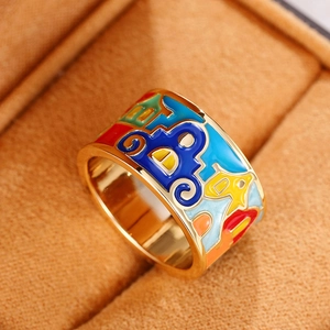 Gros plan détaillé d'une bague dorée large avec émail coloré dans un écrin