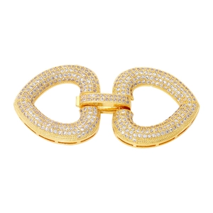 Macro detail of double heart jewelry connector in gold finish with sparkling zircons