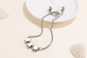 Detail of silver lily of the valley bracelet with adjustable slide clasp on beige background
