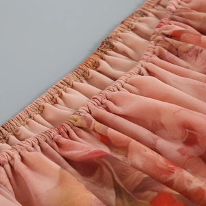 Detail of smocked elastic waist on floral chiffon fabric with soft peach and orange floral print