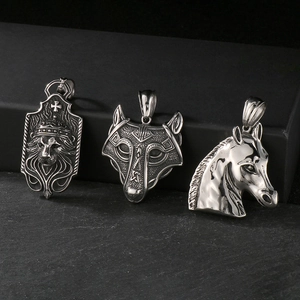 Macro detail of vintage lion, wolf, and horse pendants in aged stainless steel finish