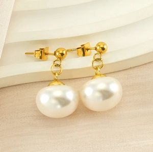 Detailed macro view of the gold-plated double-loop structure and large cream pearl earring