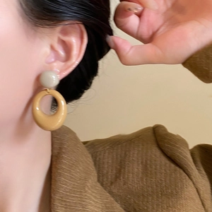 Retro mustard yellow resin hoop earrings with grey studs shown on a model side view