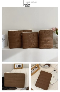 Detailed wave quilted texture on coffee brown laptop sleeve with ivory contrast zipper
