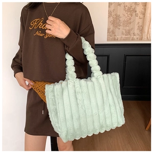 Detail of mint green plush striped tote bag with ruched handle and fuzzy faux fur texture
