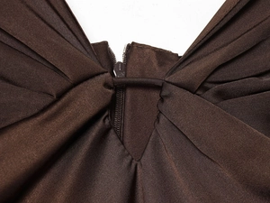 Vue macro de la robe en satin marron foncé montrant la fermeture éclair et les plis délicats