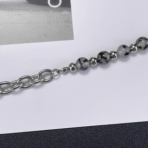 Detailed shot of silver beaded bracelet featuring grey marble stone and metal spheres