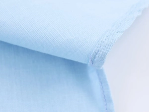 Macro detail of the high-quality stitching and light blue linen fabric texture of the shirt
