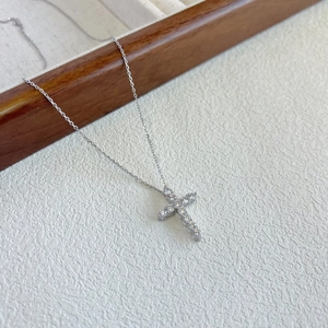 Detail view of a silver S925 cross necklace pendant with shimmering zircon pavé inlay