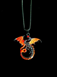 Detailed close-up of a silver dragon pendant with glowing orange wing inserts on a black background