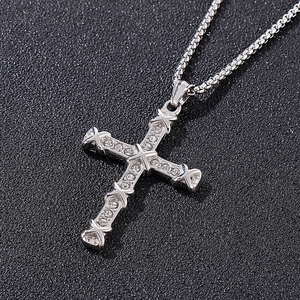 Close-up of silver titanium steel cross pendant with sparkling inset rhinestones