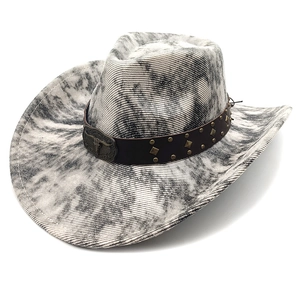 Detail of vintage suede cowboy hat with metallic bull head buckle and studded leather band