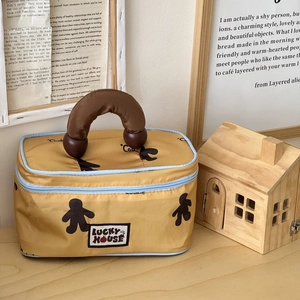 Detail of yellow fabric makeup bag with gingerbread print and wooden ball handle