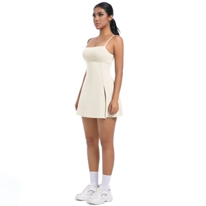 Detail of a creamy white tennis dress featuring fine straps and a side slit for movement