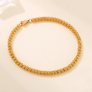 Detail of 4mm golden stainless steel beaded bracelet with secure lobster clasp closure