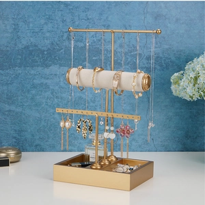 Three-tier jewelry display stand in gold metal with velvet bars for necklaces and earrings