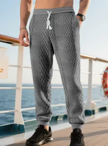 Detailed view of men's grey diamond quilted joggers with elastic drawstring waist