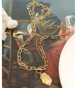 Detail of gold double-layer necklace with paperclip chain and irregular liquid metal pendant