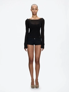 Slim fit black low-waisted shorts and sheer long-sleeved top on a model in studio