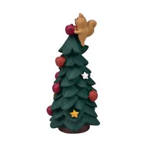 Macro shot of resin Christmas tree with squirrel, red apples and gold stars