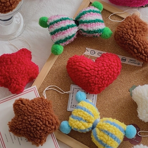 Detail of plush lamb wool Christmas charms in star and heart shapes on a cork board