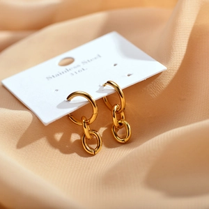 Close-up of gold 316L stainless steel drop earrings with double chain links on a card