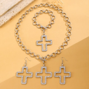 Silver jewelry set with cross pendants featuring textured finish on necklace and bracelet