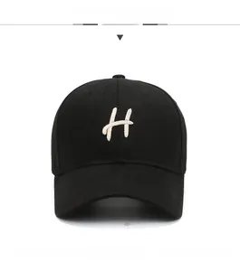 Detailed embroidery of the letter H on a black cotton baseball cap with curved brim