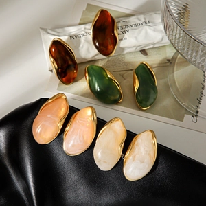 Flat lay of vintage resin earrings in amber, green, pink and beige with 18k gold plating