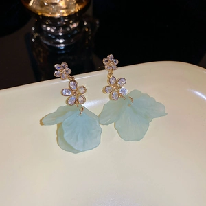 Vue macro détaillée de boucles d'oreilles fleurs vert menthe avec accents de cristal