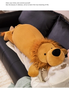 Detailed view of the soft lion plush pillow on a black sofa with fuzzy brown mane detail